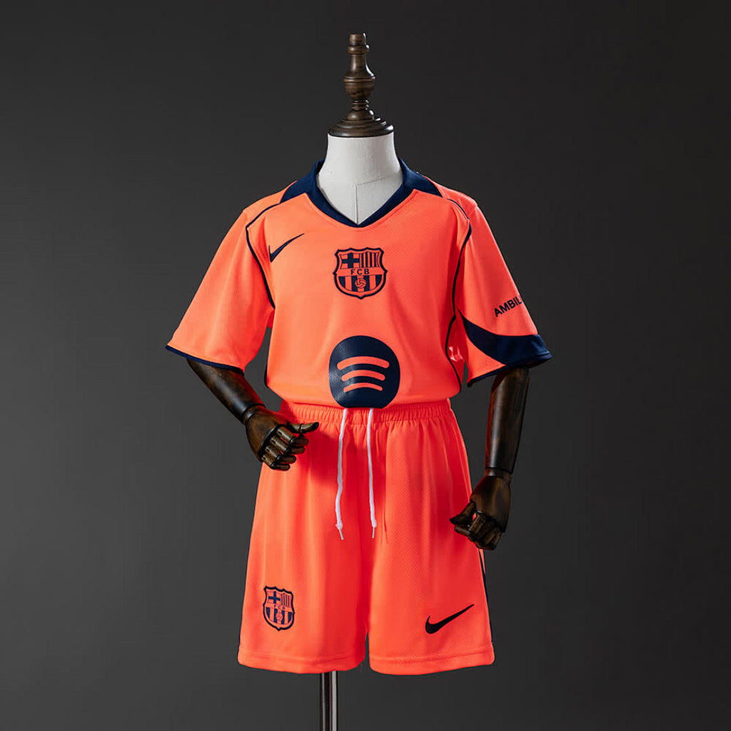 Barcelona Kids Third Away 25/26 — front view, orange shirt with FCB crest and Spotify sponsor